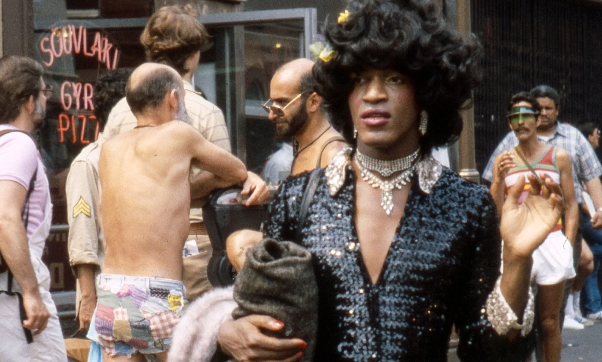 Marsha P Johnson photographed walking through a busy street.