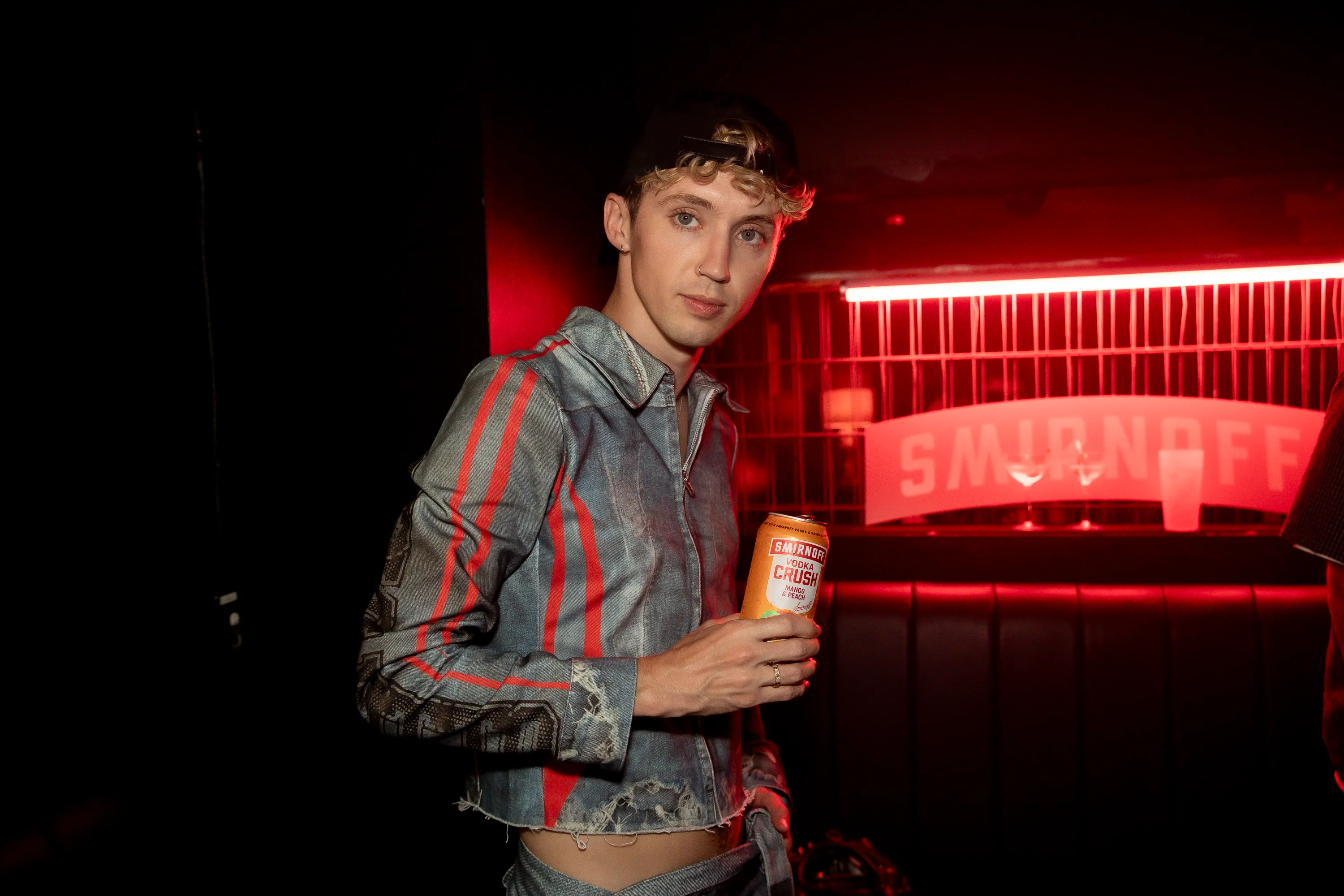 Troye Sivan holding a Smirnoff can.