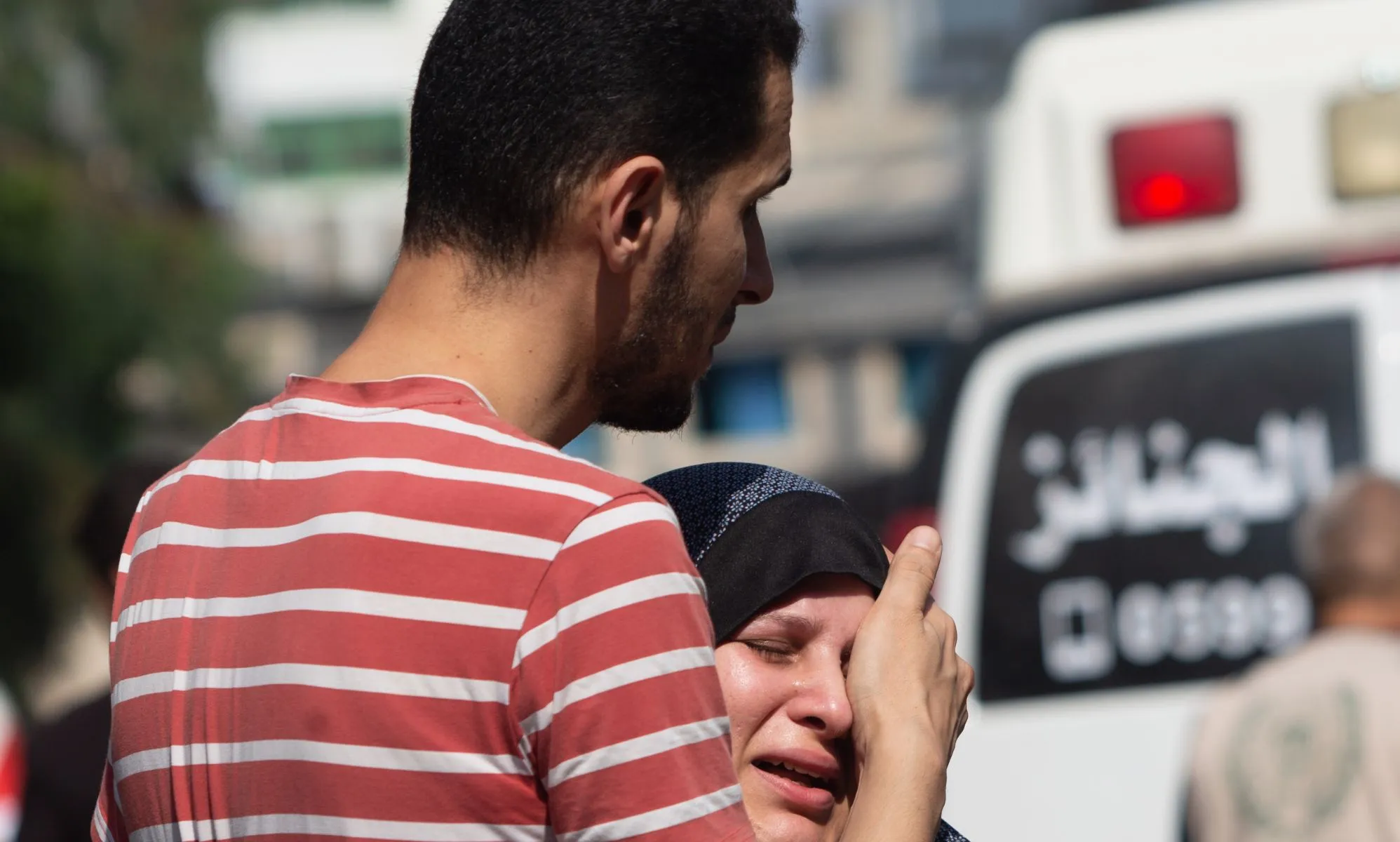 A person comforting a loved one in the Gaza Strip