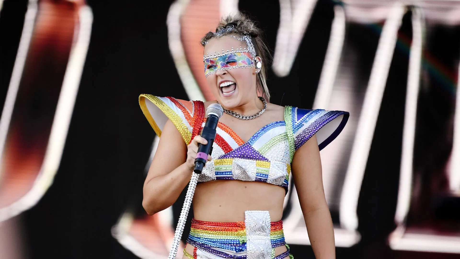 JoJo Siwa performs at a Pride event wearing rainbow-coloured outfit